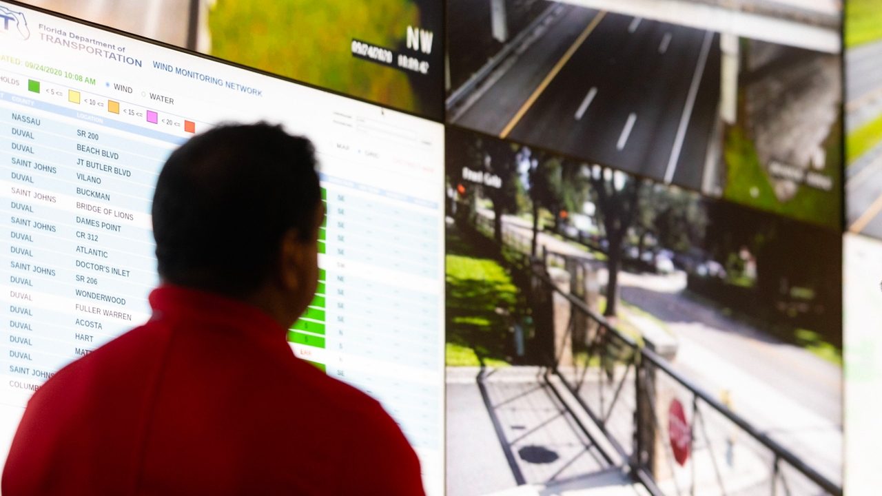 Head of operations center standing in front a screen wall